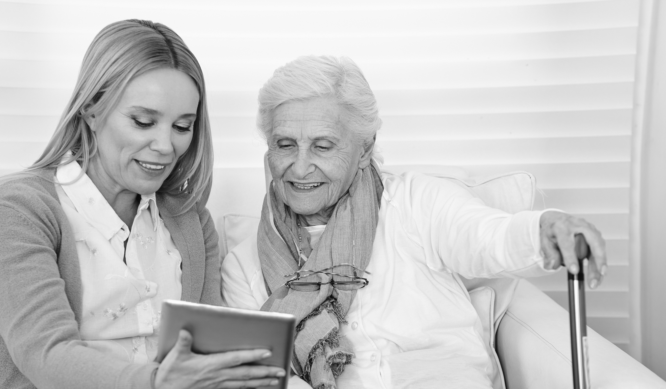 two women consulting a digital device